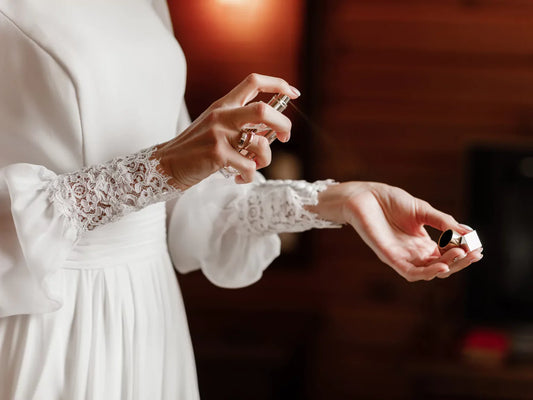 Woman applying Elvoir perfume to pulse points for long-lasting wear